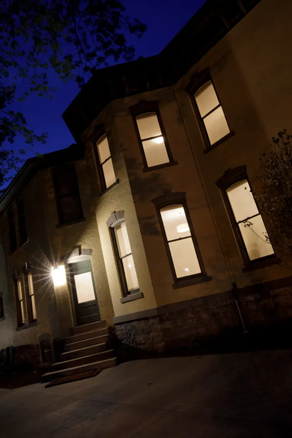The side bay and entry door glowing at night