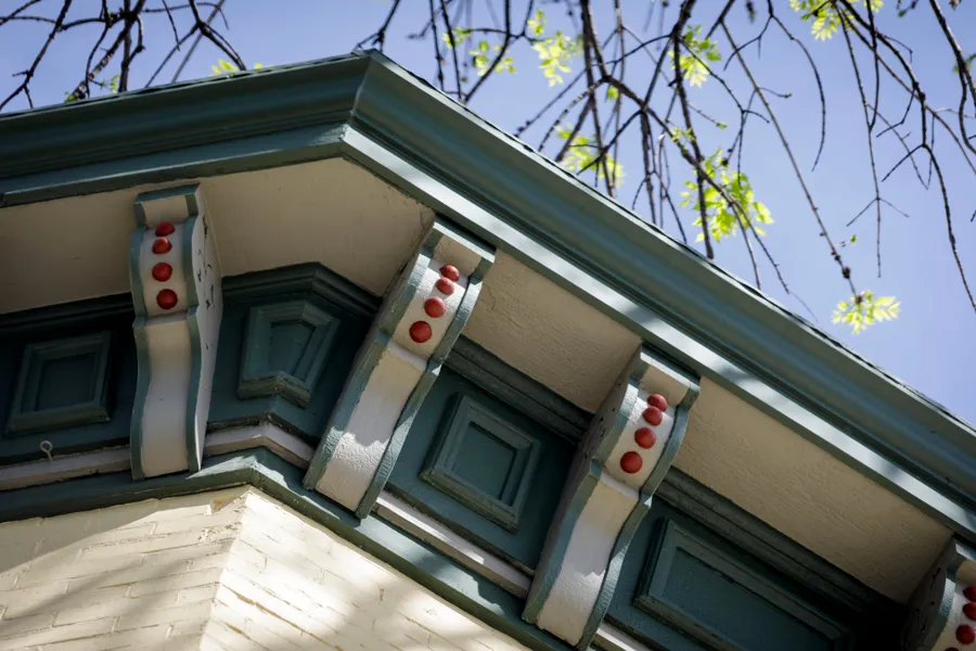 Close-up of the restored cornice brackets, painted cream and green with red dots