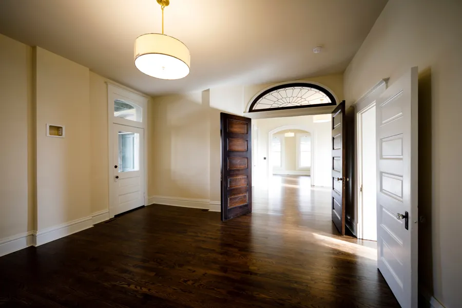Original oak double doors under a leaded glass fanlight opening into the front rooms