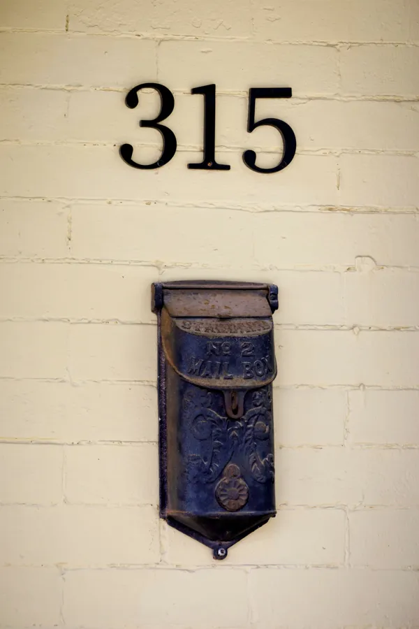 An antique cast iron No. 2 mailbox under brass house numbers 315