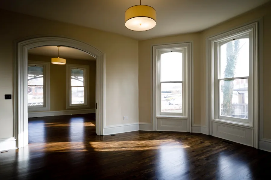 The front parlor with an arched opening to the back parlor and tall windows